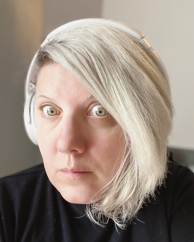 Sharyn in 2022 with white hair and white headphones