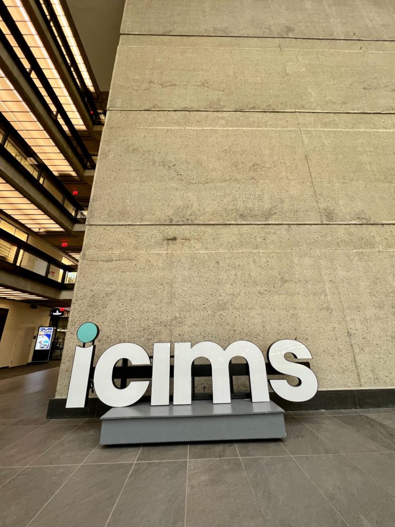 a large icims sign in the lobby of the Bell Works building