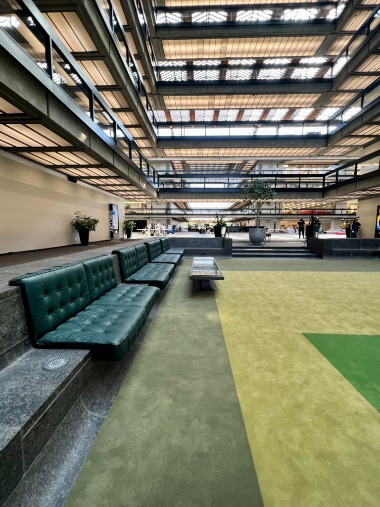 A mid century modern green sitting area in the atrium of the Bell Works building